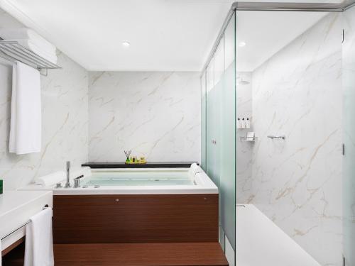 a bathroom with a tub and a shower at Elaf Taiba Hotel in Al Madinah
