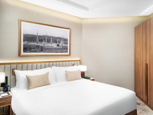 a hotel room with a bed and a picture on the wall at Elaf Taiba Hotel in Al Madinah