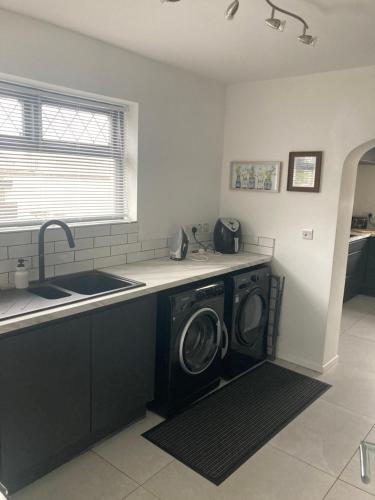 a kitchen with a washer and dryer on a counter at North Coast Retreat in Portstewart