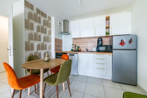 a kitchen with a table and chairs and a refrigerator at Parisian Terrace - Close to Orly and RER Station C, D in Athis-Mons