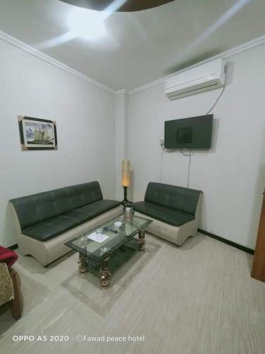 a living room with two green couches and a table at Peace Hotel Fizagat, Swat in Swat