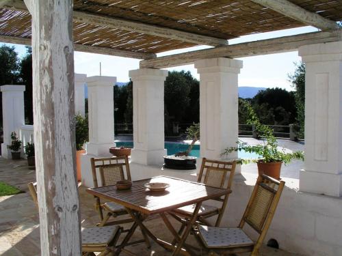 a wooden table and chairs on a patio at B&B Lamascopone in Fasano
