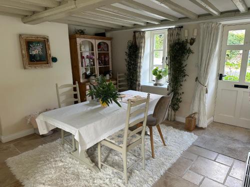 a dining room with a white table and chairs at Newmans Cottage in Burford