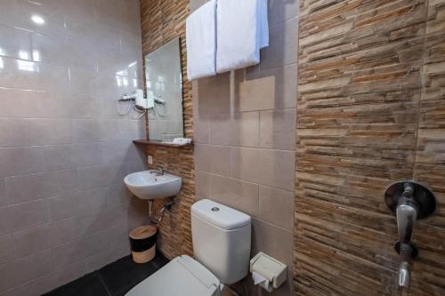 a bathroom with a white toilet and a sink at Kubu Belona Canggu in Canggu
