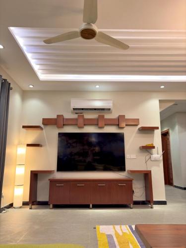 Una sala de estar con un televisor de pantalla plana grande. en The Grand Haven - 3BHK, en Islamabad