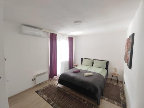 a bedroom with a bed and a large window at Spacious and Modern Apartment in Town Center in Konjic