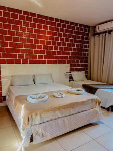 a bed in a room with a brick wall at POUSADA MARTINS in Carolina