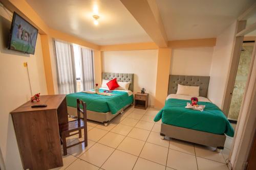 Una habitación de hotel con dos camas y un escritorio. en VILLA andina cusco, en Cusco