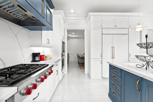 a kitchen with white cabinets and blue appliances at GLOBALSTAY Luxury 4-Bedroom House near Wonderland with Free Parking in Vaughan