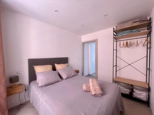a bedroom with a large bed with purple sheets at Appartement T3 Place du Marché in Bastia