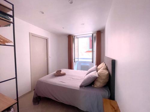 a small bedroom with a bed and a window at Appartement T3 Place du Marché in Bastia