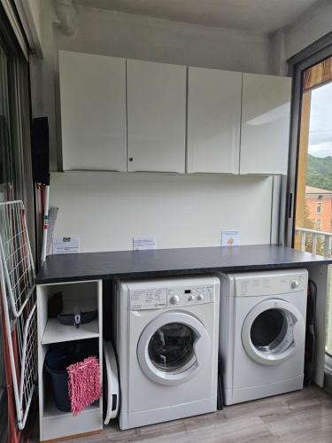 a kitchen with a washer and dryer in a room at Idéal long séjour, Souvenirs de Provence,T2 classé, vue sur les montagnes, toutes commoditées! in Digne-les-Bains
