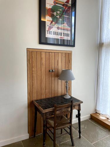 a table with a lamp on it next to a door at Private & Spacious Cotswold Barn in Hankerton