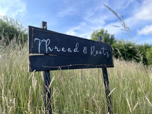 a sign in the middle of a field of tall grass at Private & Spacious Cotswold Barn in Hankerton