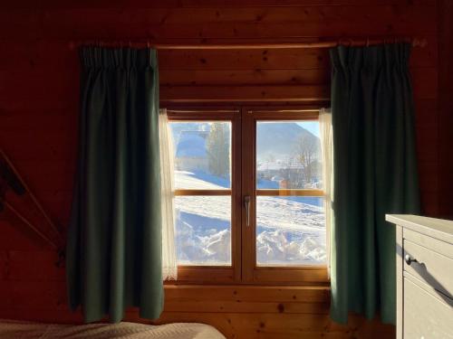 a window in a log cabin with snow outside at Haus Otis in Bad Mitterndorf