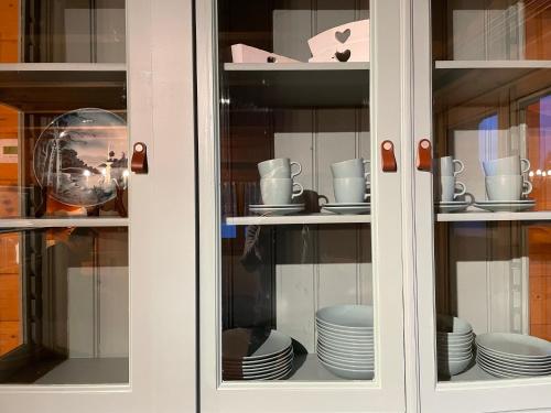 a cabinet with plates and cups and dishes in it at Haus Otis in Bad Mitterndorf