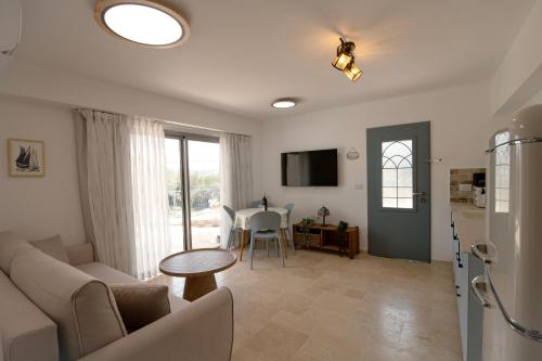 a living room with a couch and a table at מתחם "חוויה של שקט"- עם בריכה משותפת קרוב לכנרת in Livnim