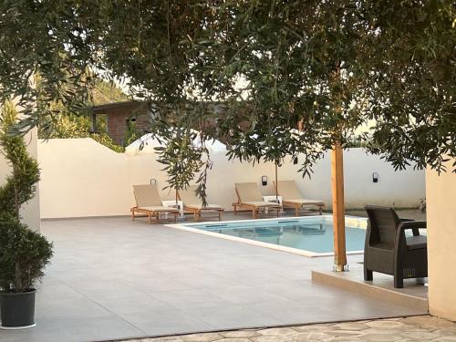 a swimming pool with lounge chairs next to a building at Poolside Bliss - Escape & Relax in Kalmet