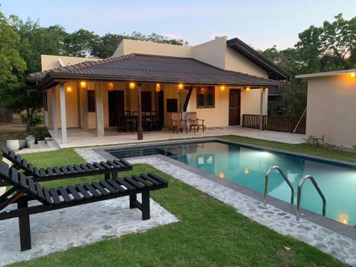 a home with a swimming pool and a house at Aaryana Lagoon in Tangalle