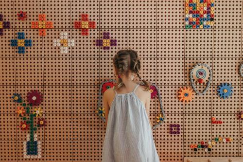 a young girl in a white dress standing in front of a wall at Alpina Alpendorf in Sankt Johann im Pongau