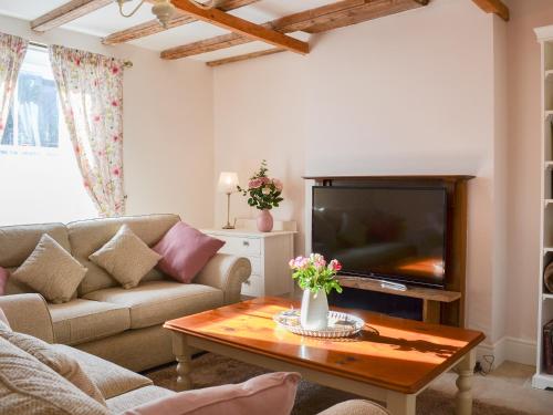 a living room with a couch and a tv at West House Farm in Filey
