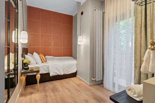 um pequeno quarto com uma cama e uma janela em Tova Pearl - Cozy, Modern 2BR Apt, DT, Ultracentral, Chabad across street, 20 min walk to Old Town em Bucareste