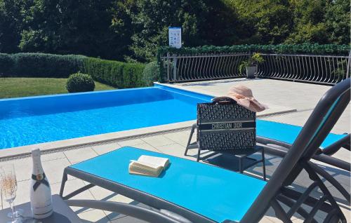 a man sitting in a chair next to a swimming pool at Villa Heaven in Heki