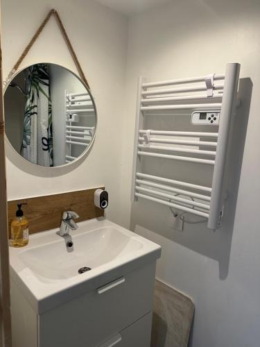 une salle de bains avec un lavabo blanc et un miroir dans l'établissement L'Aire des montagnes, à Bolquère-Pyrénées 2000