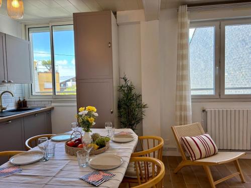 a kitchen with a table with a bowl of fruit on it at Les Cocons d'Agathe, La Marinière, la plage à pieds in Larmor-Plage