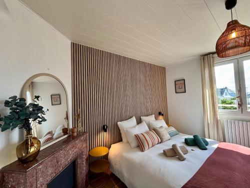 a bedroom with a large bed and a mirror at Les Cocons d'Agathe, La Marinière, la plage à pieds in Larmor-Plage