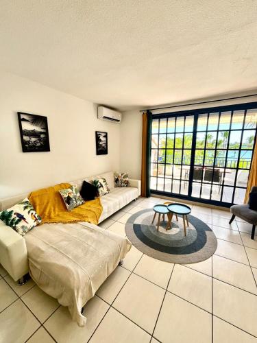 a living room with a couch and a table at Blue Marine Apartment in Baie Nettle