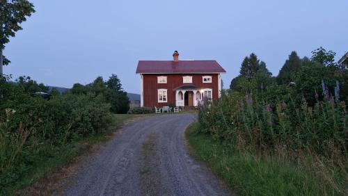 a dirt road leading to a large red house at Solberg Inn 