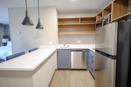 a kitchen with a sink and a refrigerator at Beachwood Extended Suites in Beachwood