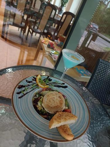 a plate of food on a table with a drink at Hotel Sobieszewo in Gdańsk