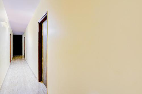 an empty corridor with a door in a white wall at Hotel O YUVI in New Delhi