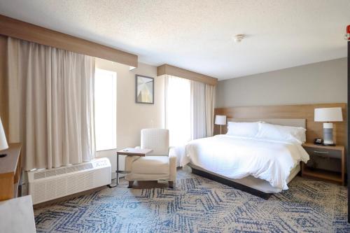 a hotel room with a bed and a chair at Beachwood Extended Suites in Beachwood