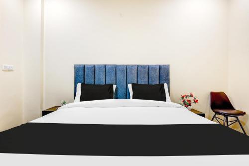a bedroom with a large bed and two chairs at Hotel O YUVI in New Delhi