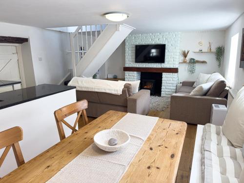 a kitchen and living room with a table and a couch at Fisherman's Cottage on Chesil Beach in Castletown