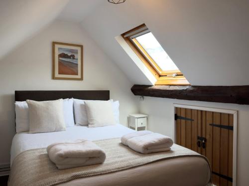 a bedroom with a bed with two pillows on it at Fisherman's Cottage on Chesil Beach in Castletown