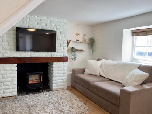 a living room with a couch and a fireplace at Fisherman's Cottage on Chesil Beach in Castletown
