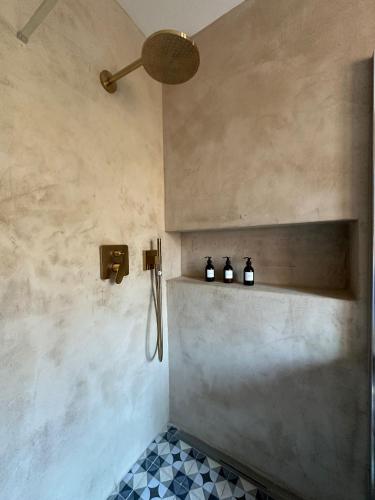 a bathroom with a shower with three bottles on a shelf at B&B Mila in Oprtalj