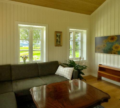 a living room with a couch and a coffee table at Historic Croft With Views Over Lake Mjøsa in Ottestad