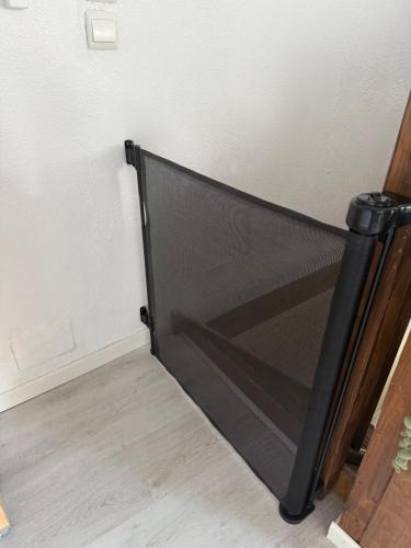 a black bed in the corner of a room at L'Alcôve Alsacienne avec climatisation et terrasse in Entzheim