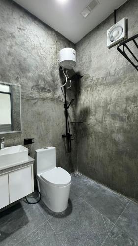 a bathroom with a white toilet and a sink at Reinforce Residence in Thulusdhoo