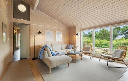 a living room with a couch and chairs and windows at Buller in Fanø