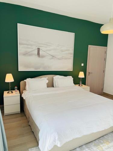 ein Schlafzimmer mit einem großen weißen Bett und einer grünen Wand in der Unterkunft The Hive at Yas Island in Abu Dhabi
