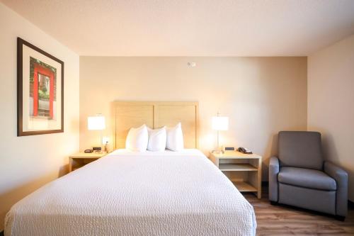 a hotel room with a bed and a chair at Extended Stay America Suites - Cleveland - Beachwood - Orange Place - South in Orange