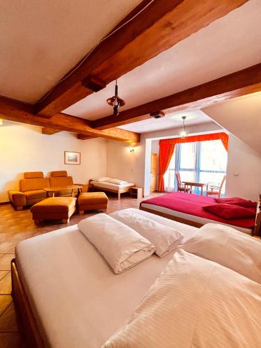 a bedroom with two beds and a living room at Penzión Teniscentrum in Tatranská Lomnica