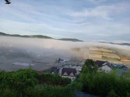 a view of a town in the fog with houses at NEST House in Ấp Kim Thạch