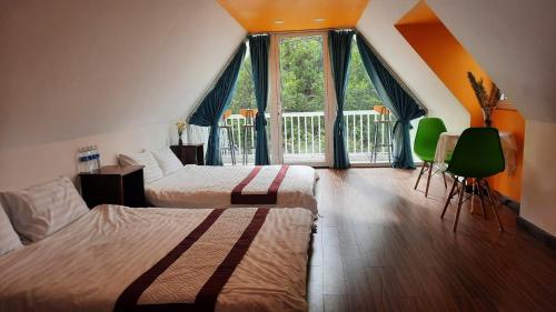 a hotel room with two beds and a large window at NEST House in Ấp Kim Thạch